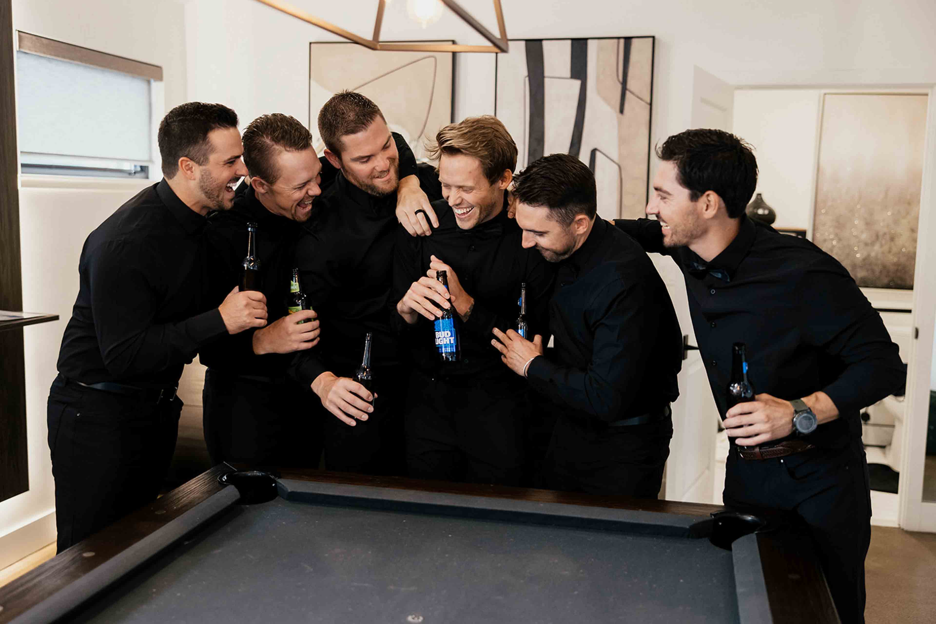 The Elm Estate Men hugging the groom with beers in their hands