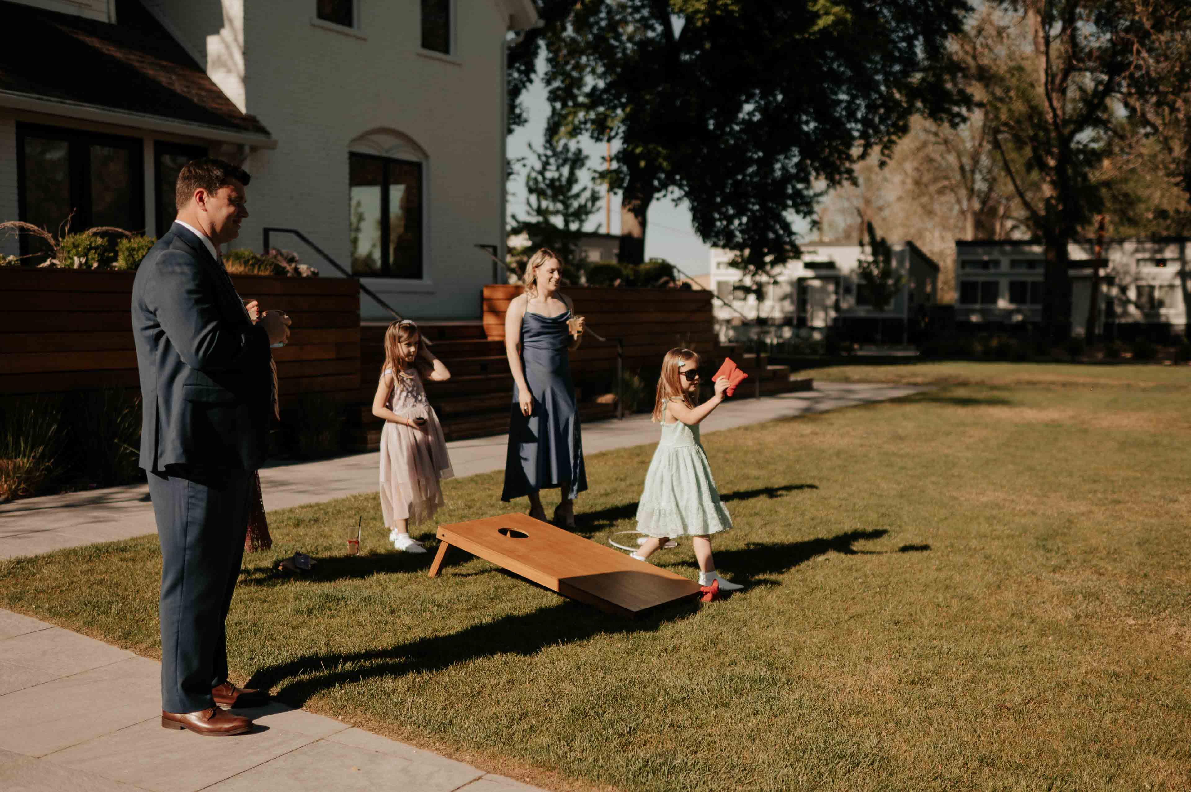 The Elm Estate family of four playing corn hole outside on the lawn of the Elm Estate