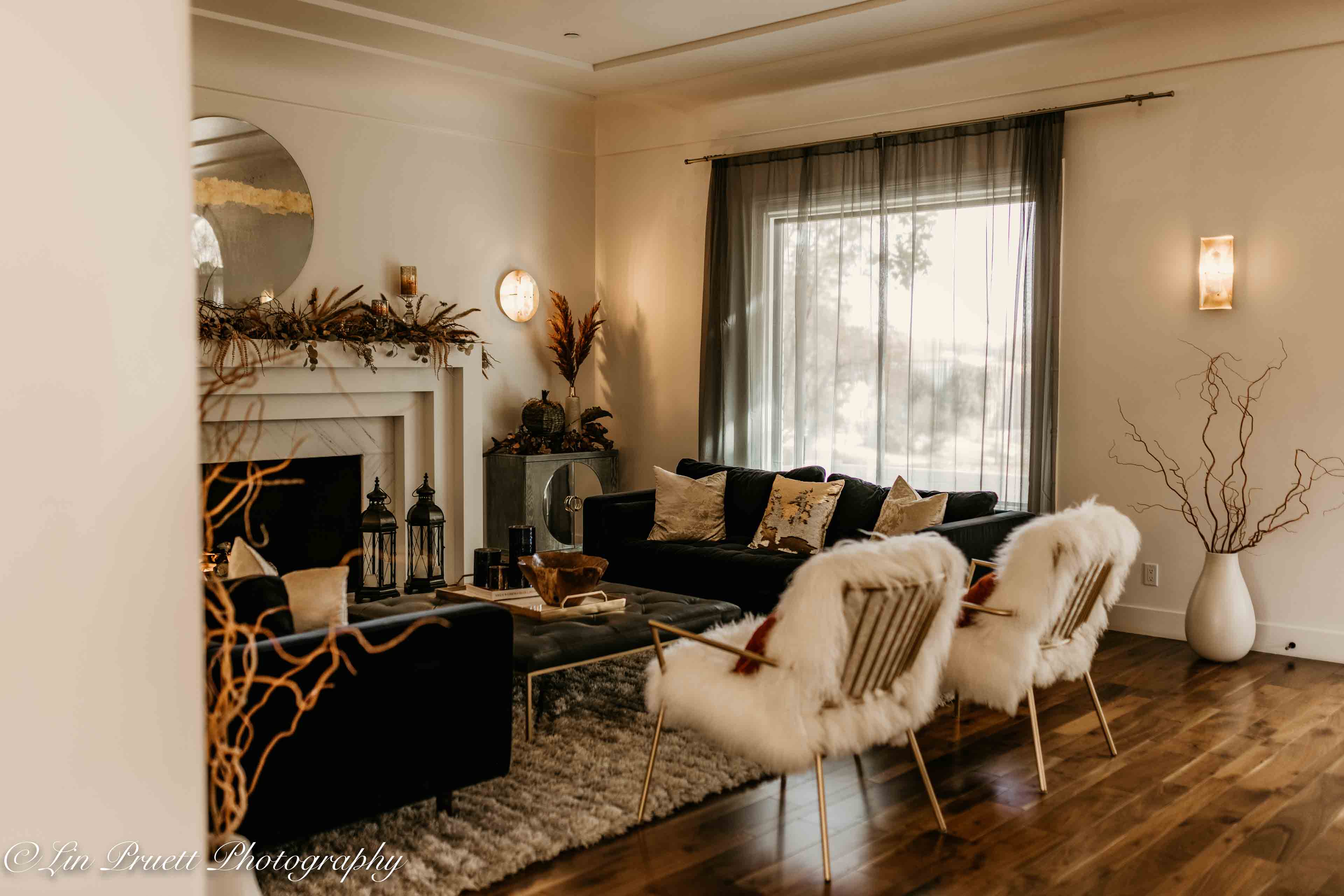 cozy living room with white fluffy chairs and a sofa