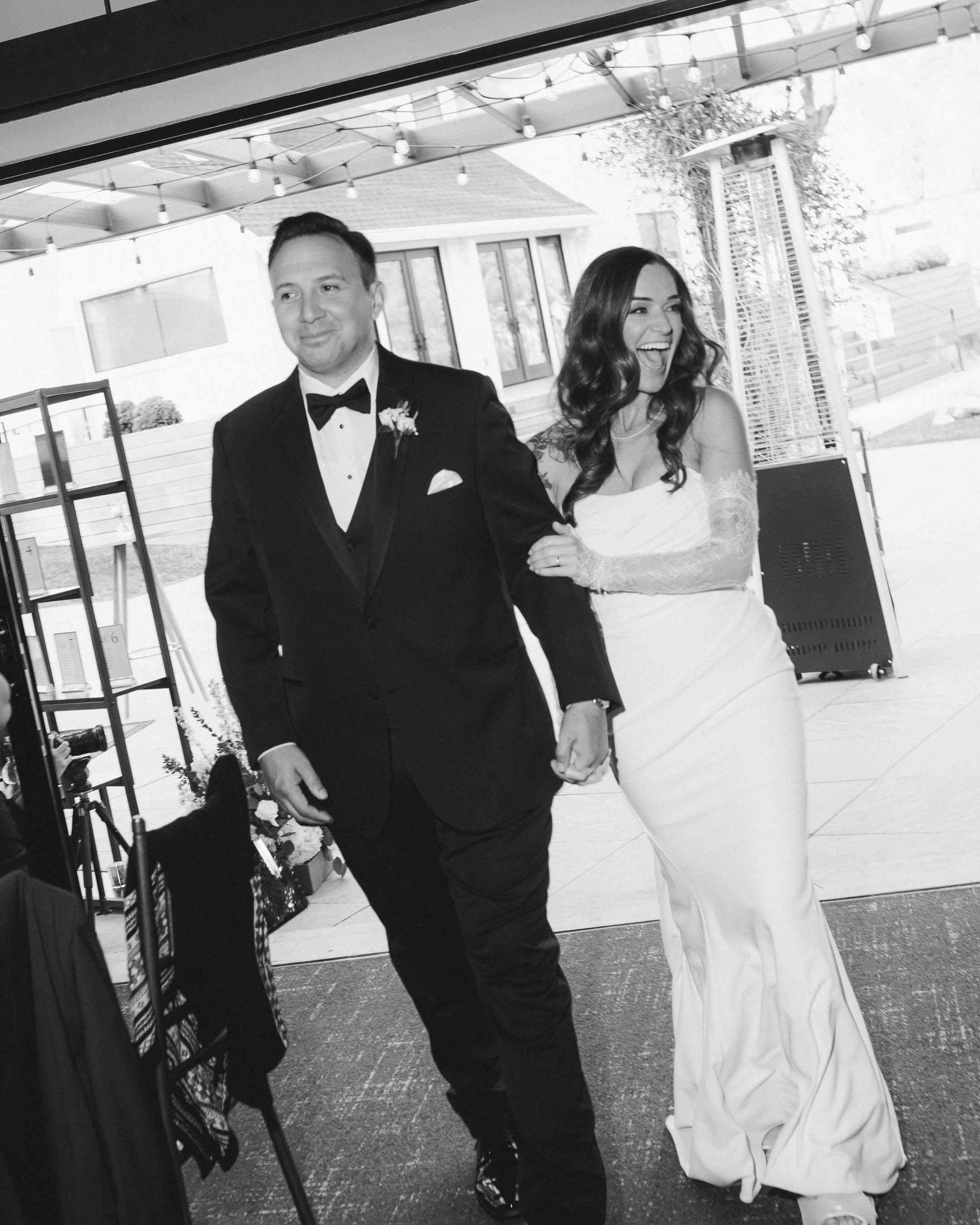 Bride and groom holding hands entering ceremony room