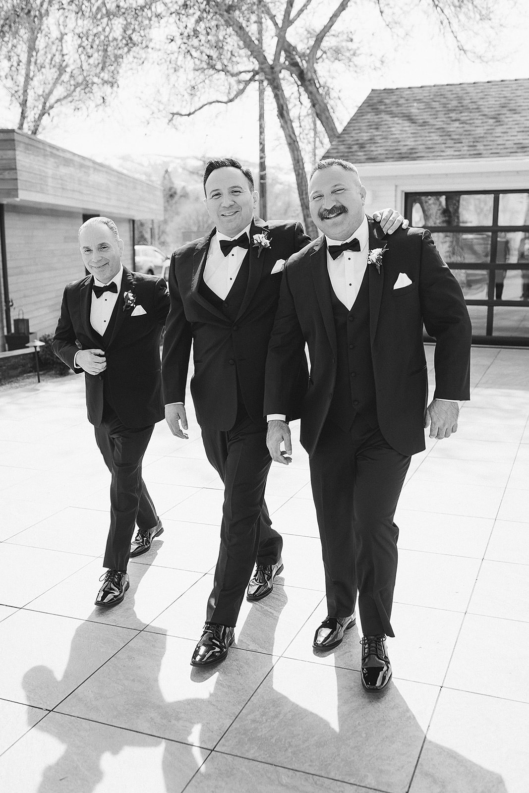 Groom of the wedding with 2 other man walking and smiling