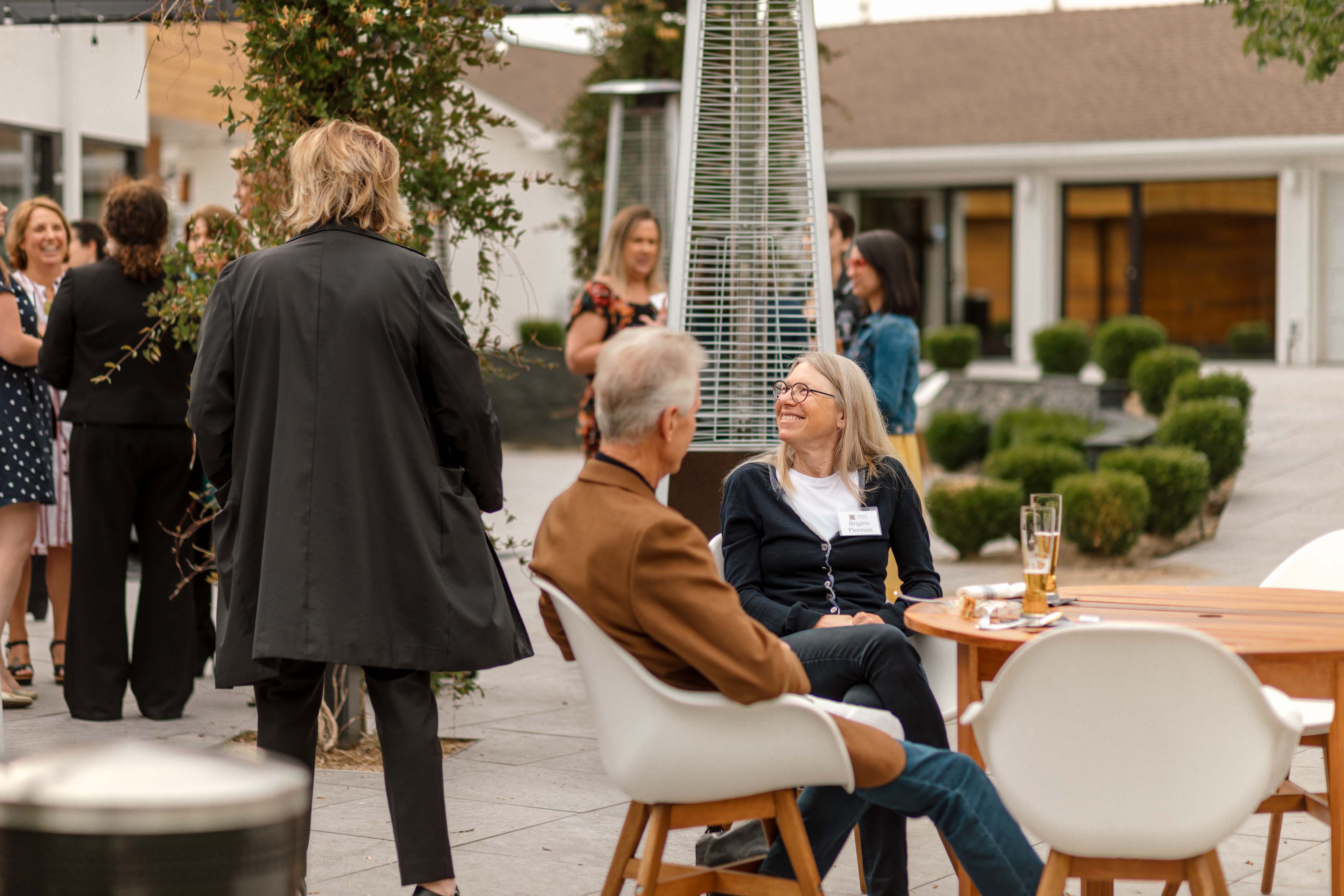 Woman and Man Smiling Sitting Outside The Elm Estate Corporate Event