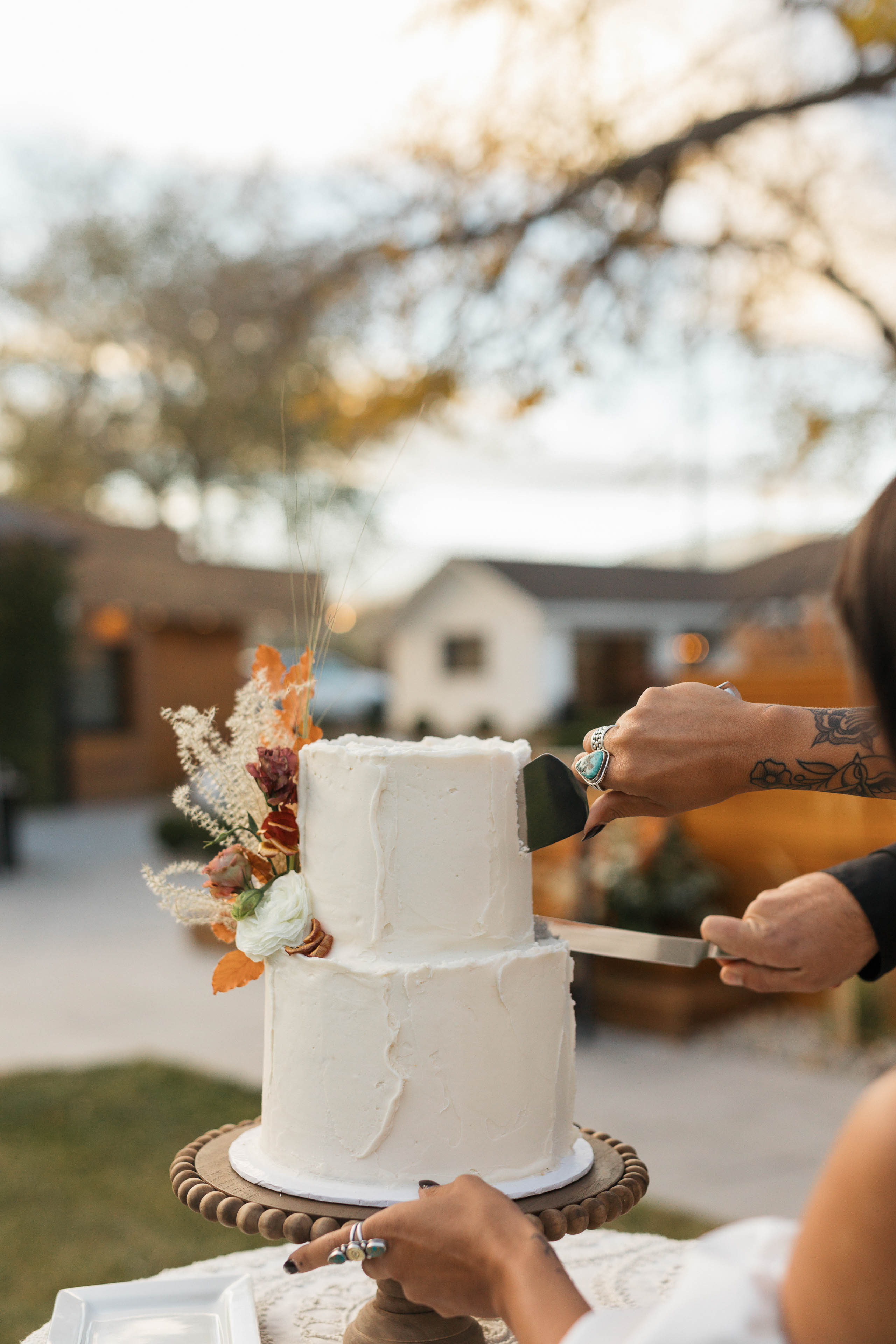 a couple cutting a wedding cake at an outdoor venue 1