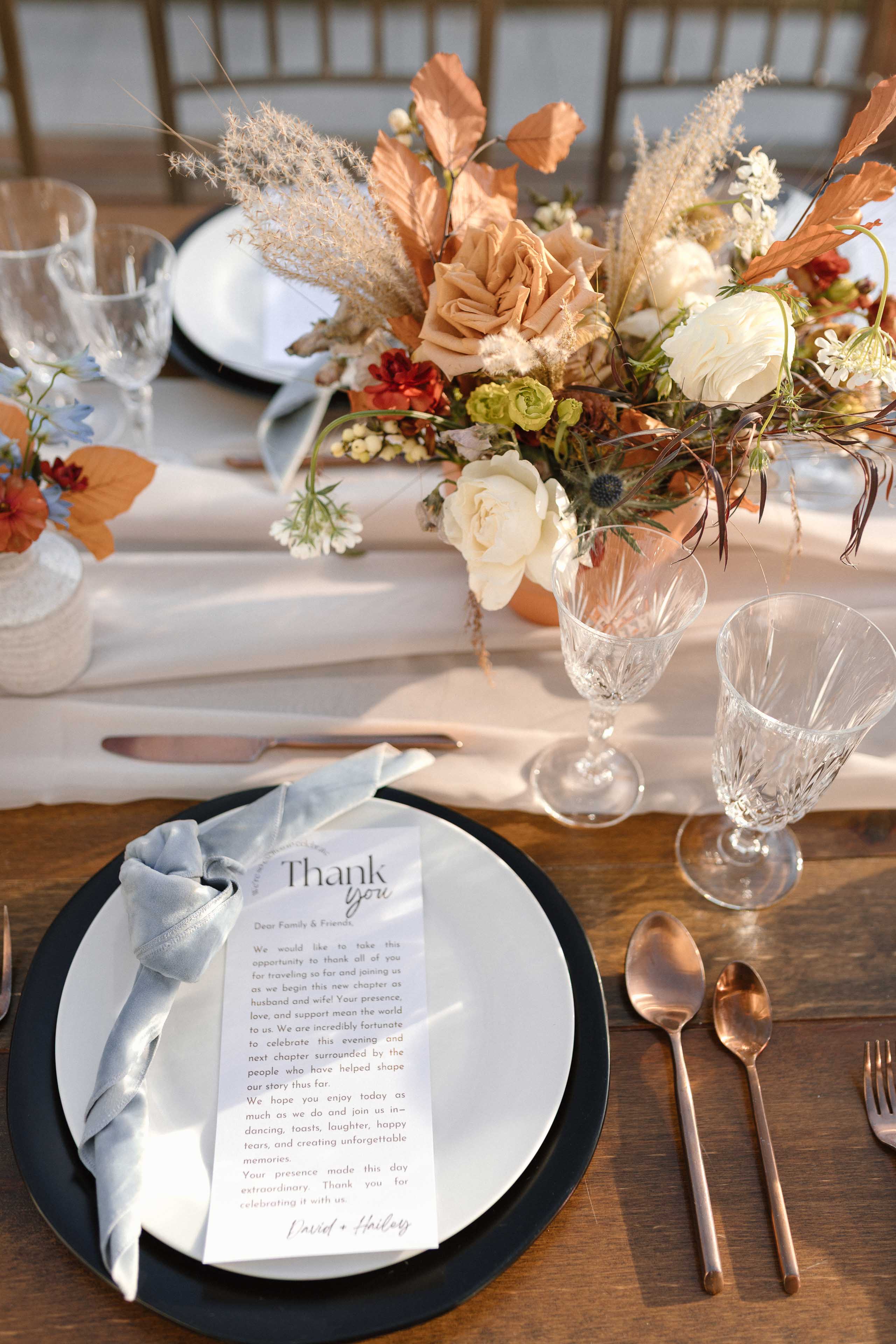 a dinner plate set with tablewear linens and fall colored flowers