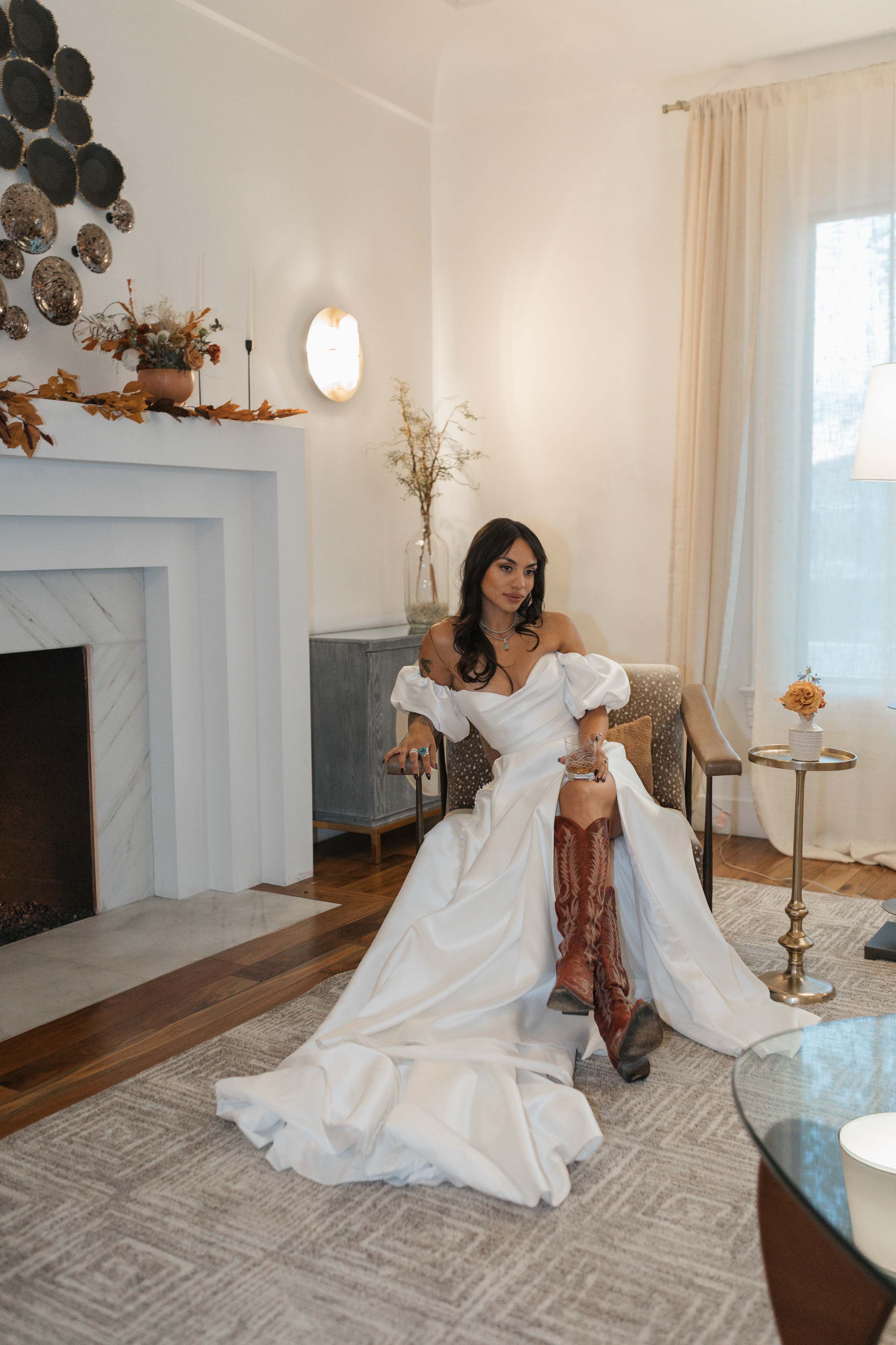a woman lounging in a chair near a fireplace inside the elm estate