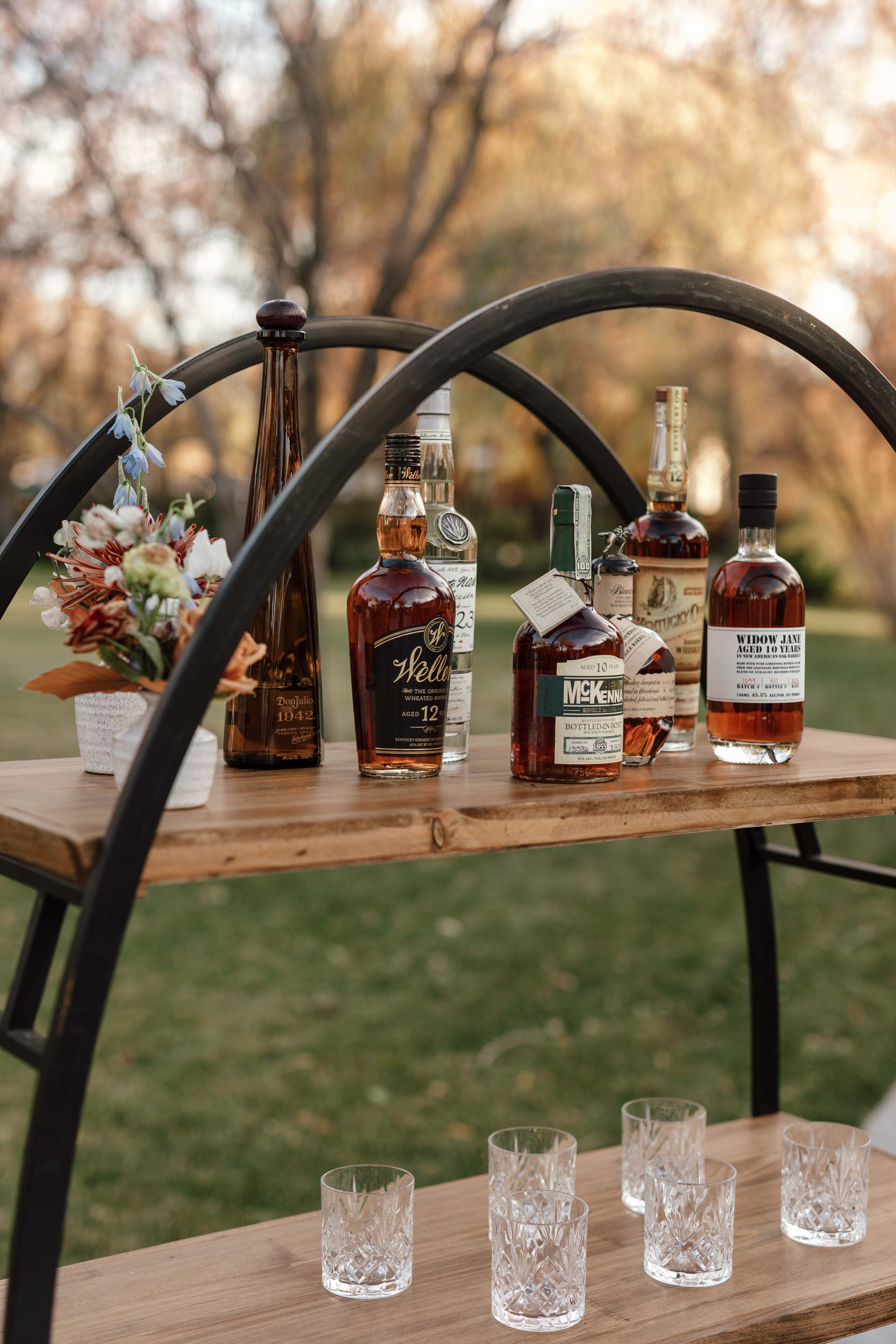 a wooden shelf with whiskey bottles and glasses
