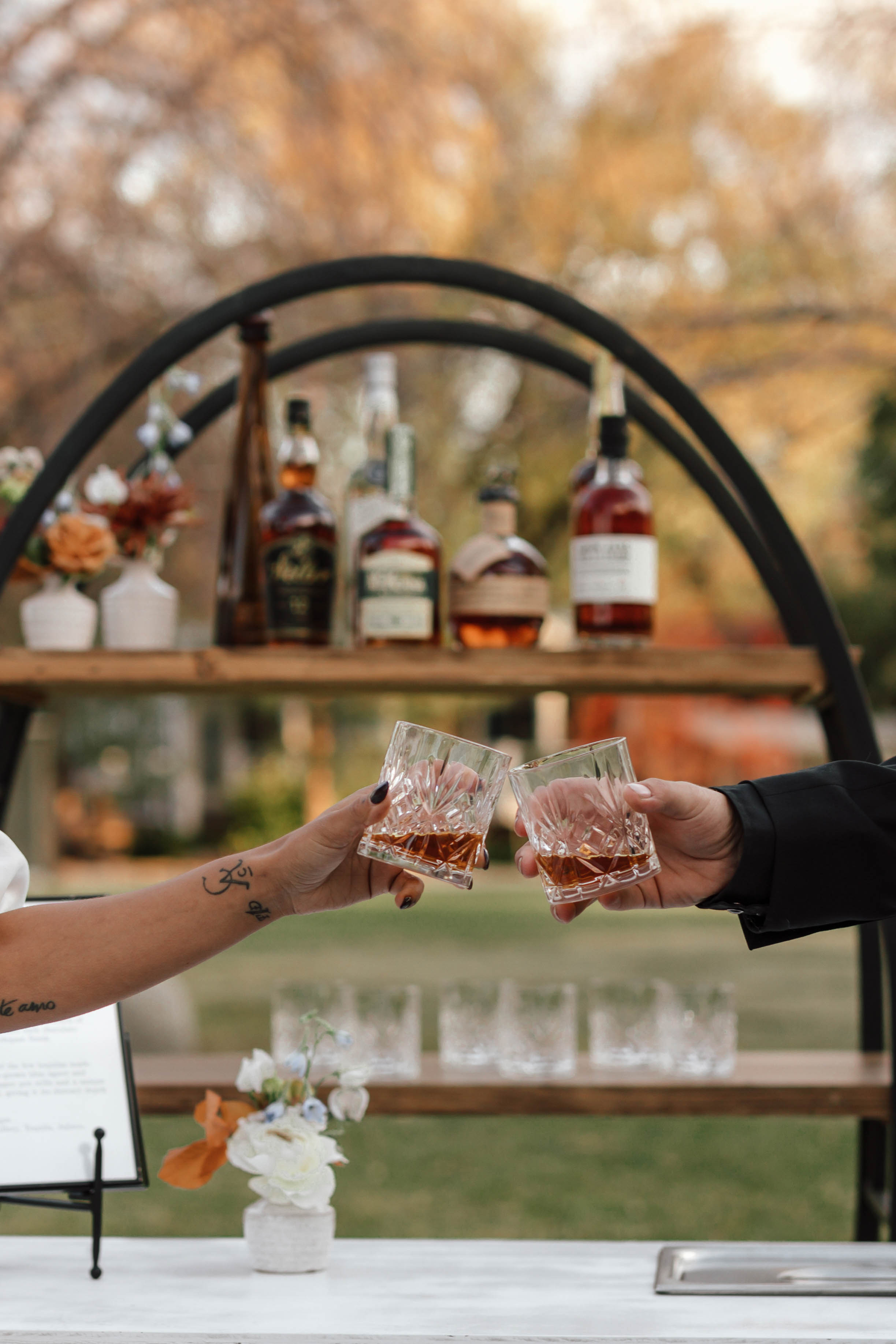 two people cheersing their drinks together outdoors